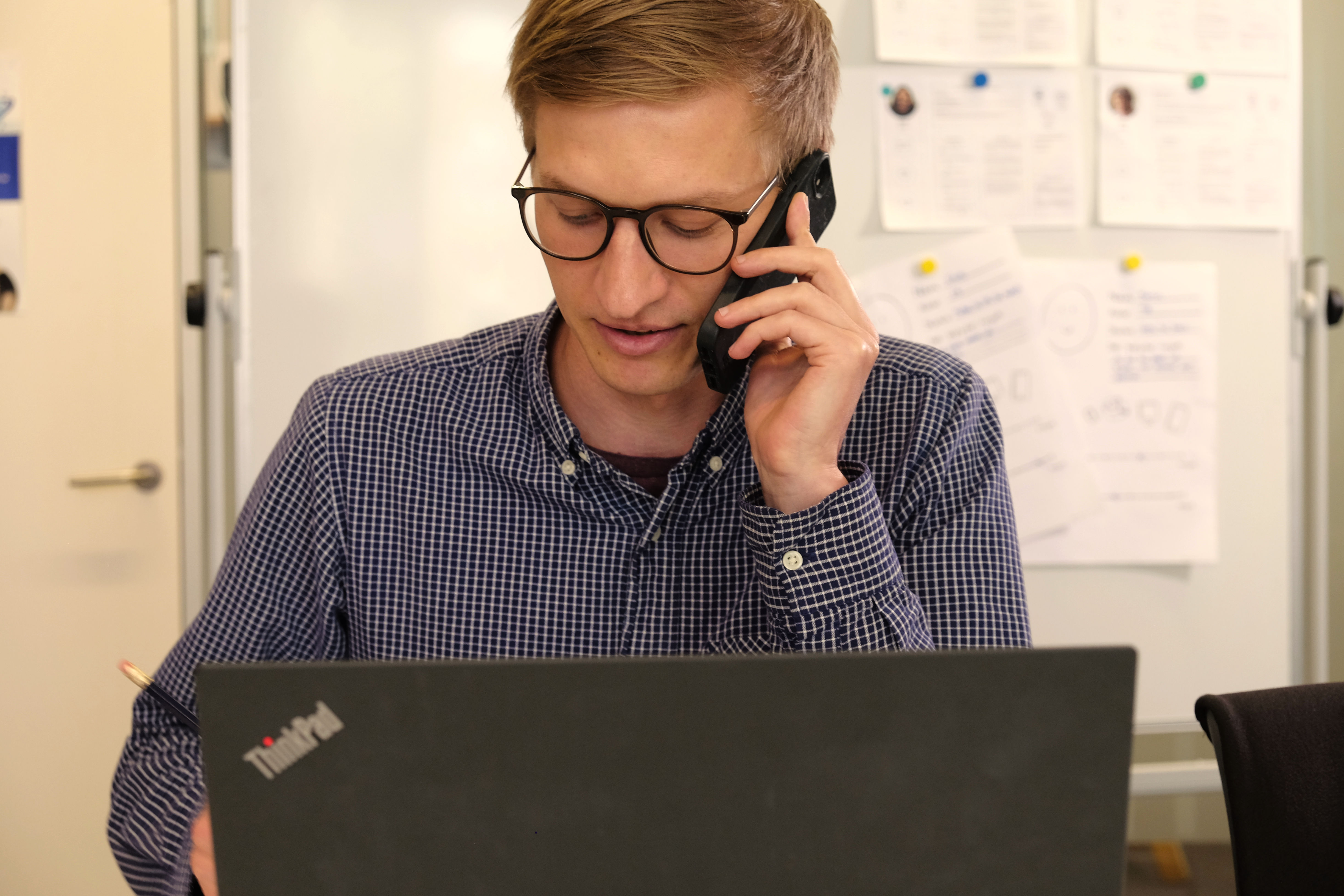 Person ved computer der taler i telefon