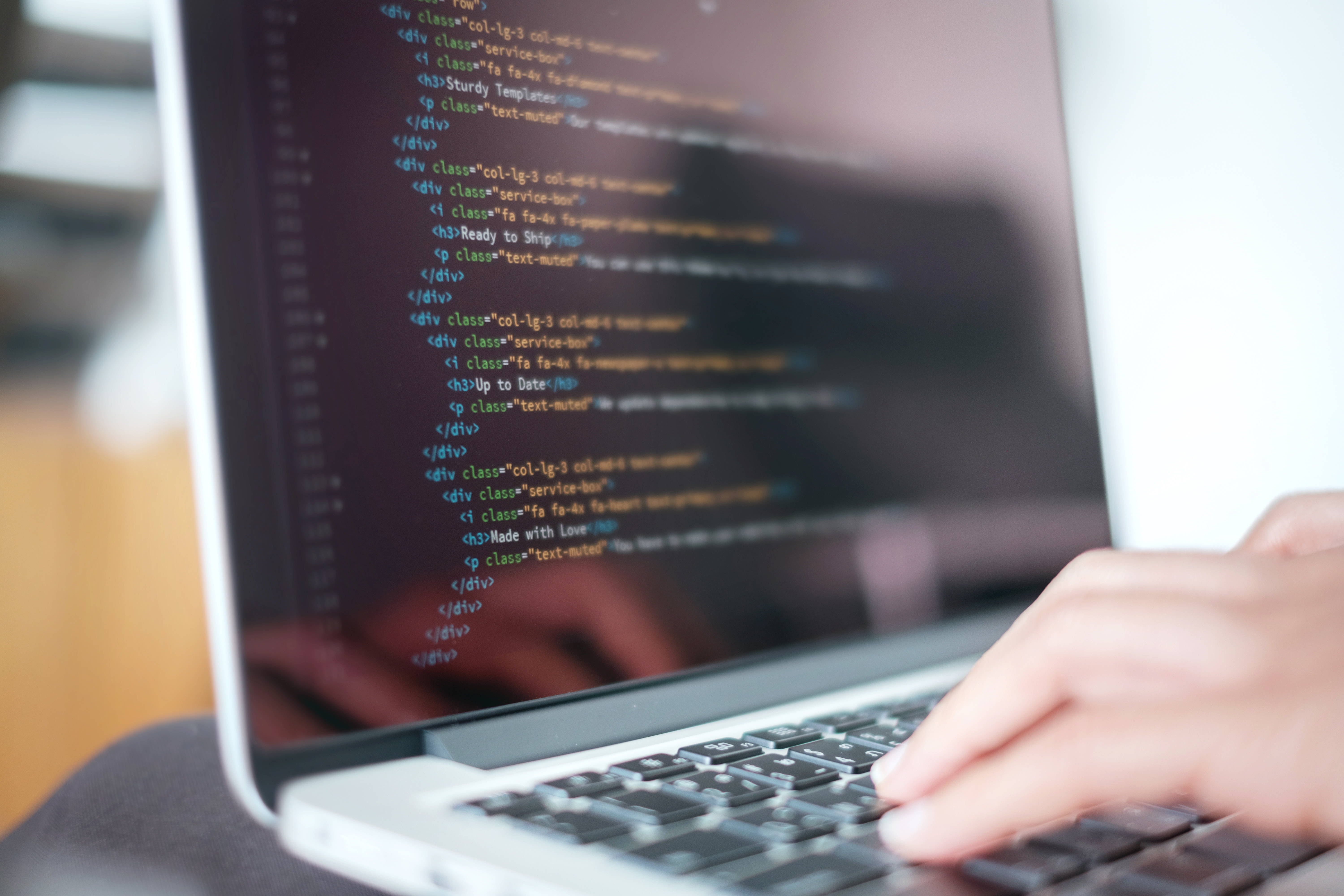 Person med computer med html-kode på skærmen